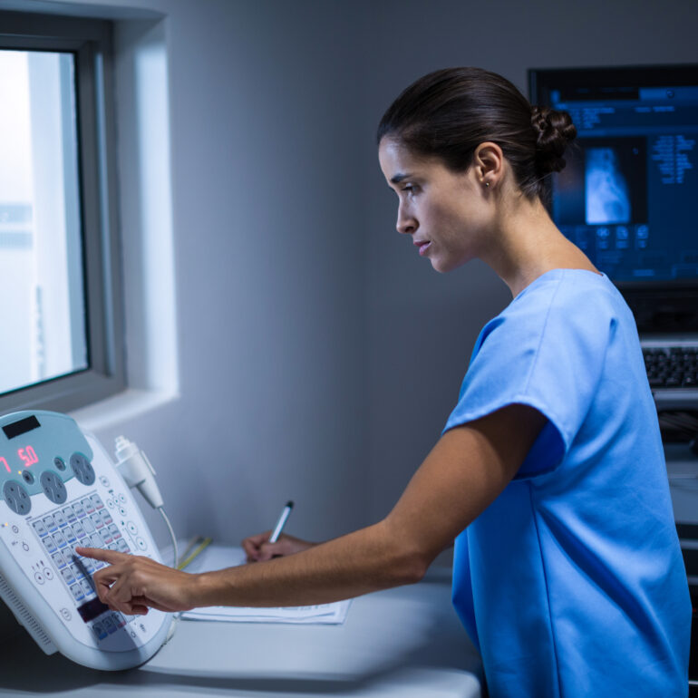 Nurse taking notes in x-ray room at hospital